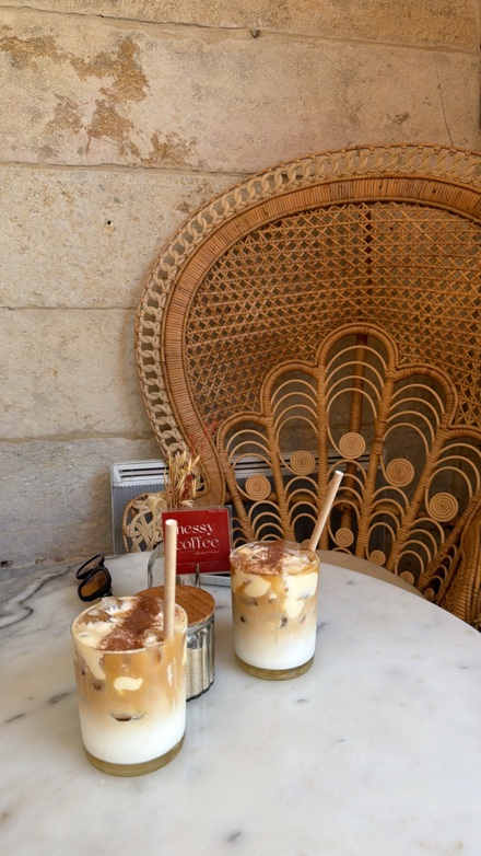 Deux lattes banana bread glacés sur une table en marbre chez Nessy Coffee
