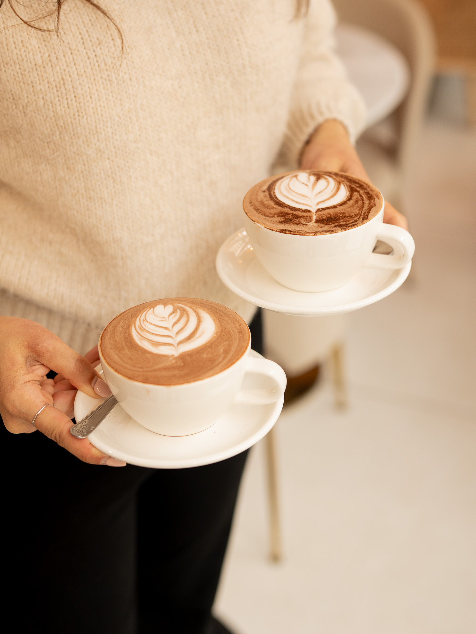 Deux cappuccinos latte art servis dans la salle