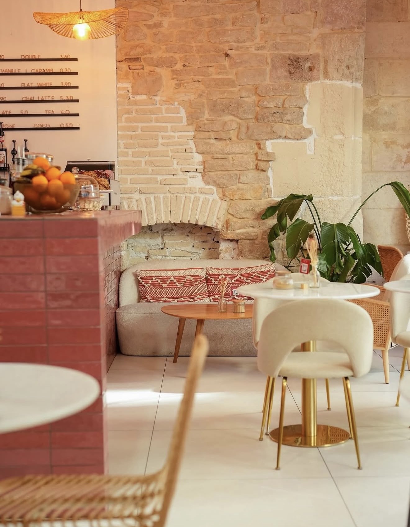 Intérieur de Nessy Coffee — comptoir, mur en pierre et banquette cosy